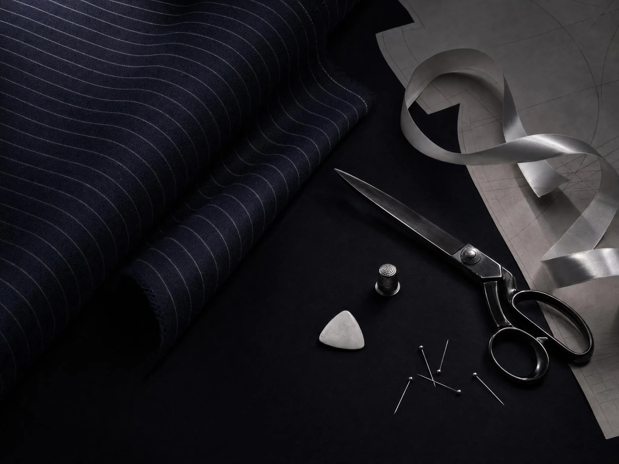 Atelier still life: navy pinstripe wool, tailoring shears, thimble and white satin ribbon